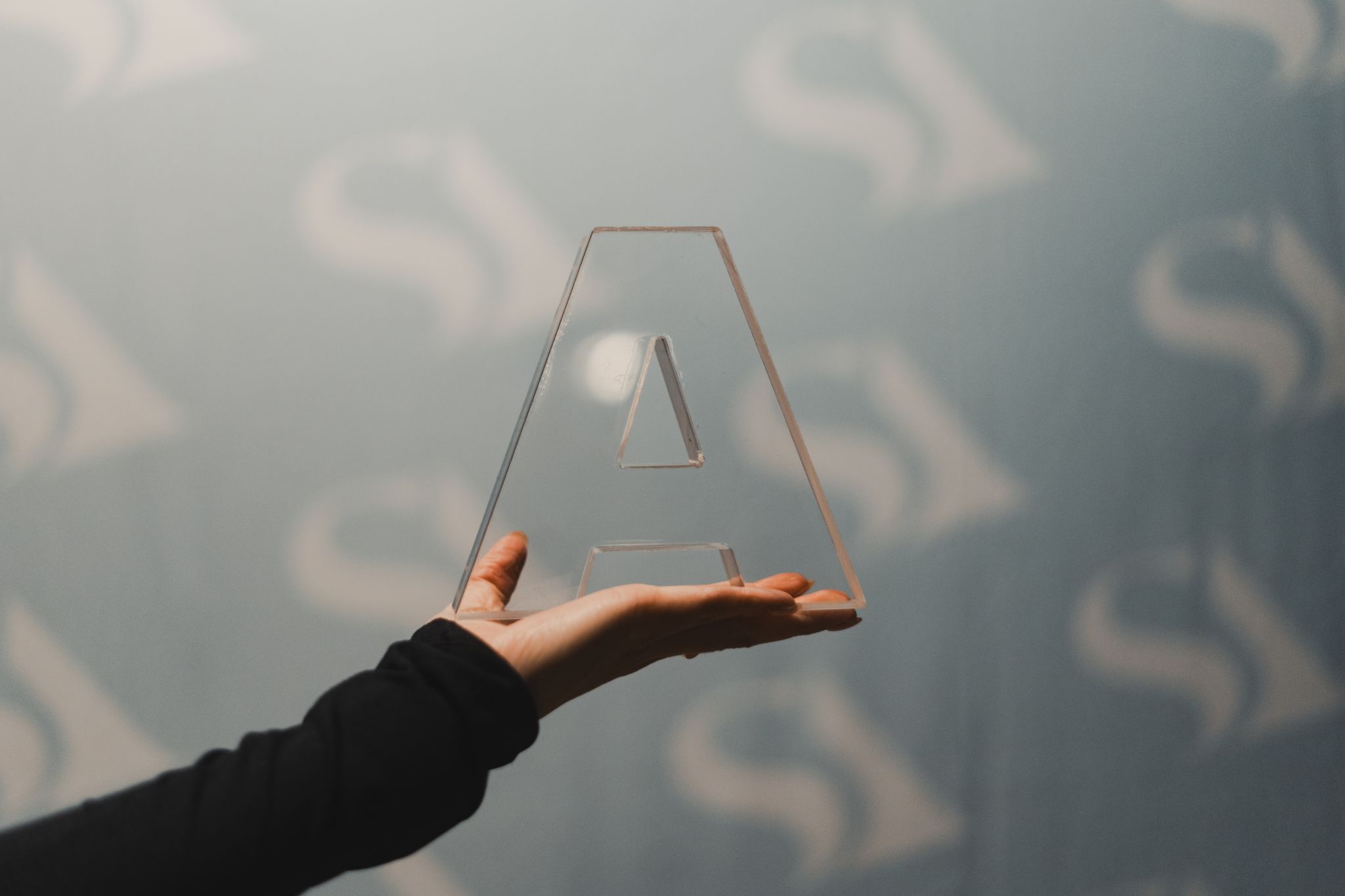 Hand holding A-shaped award